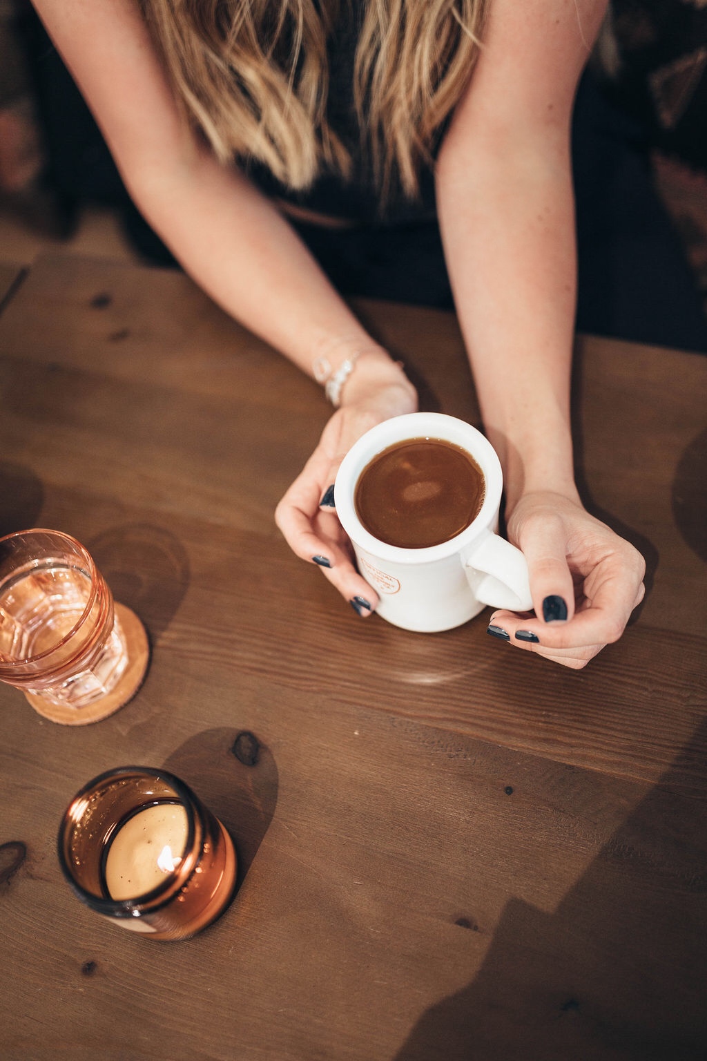 ditching starbucks habit | WHY I'M DITCHING MY STARBUCKS ADDICTION AND HOW YOU CAN TOO by popular San Francisco life and style blog, Just Add Glam: image of a woman sitting at a table and holding a coffee cup. 